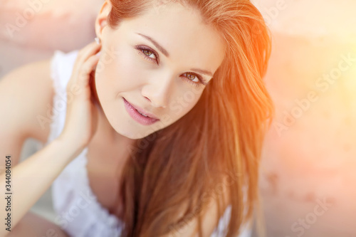 Beautiful woman. Young girl with rays of sunset bill. Portrait. 