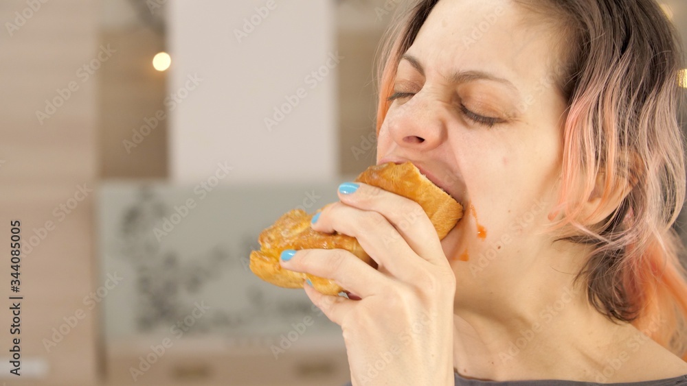 Portrait of caucasian young beautiful woman greedily eagerly eating food during quarantine due to coronavirus. Charming happy hungry woman on diet laugh and biting off big meat pie. Close up. Portrait of caucasian young beautiful woman greedily eagerly eating food during quarantine due to coronavirus. Charming happy hungry woman on diet laugh and biting off big meat pie. Close up.