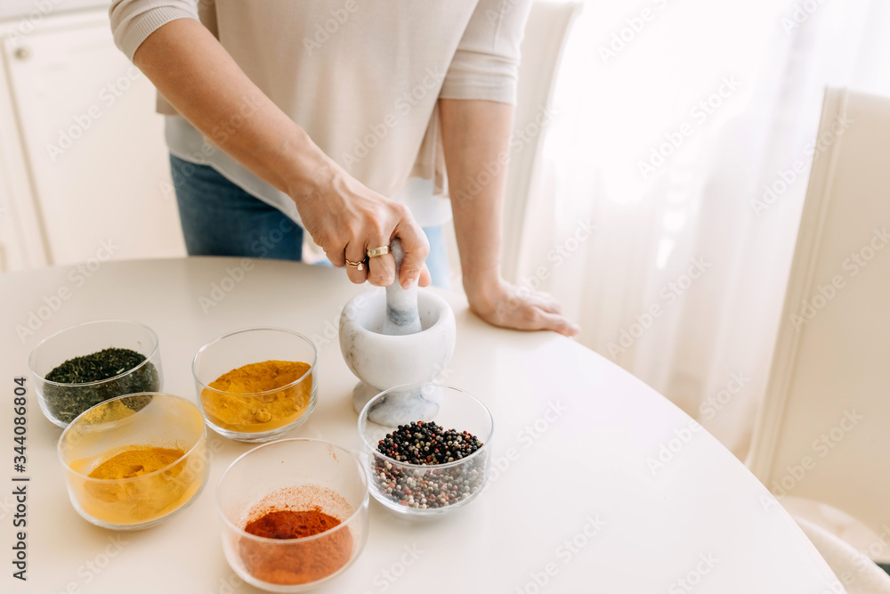 Woman grinding mix of peppers with a stone mortar. Woman grinding mix of peppers with a stone mortar.