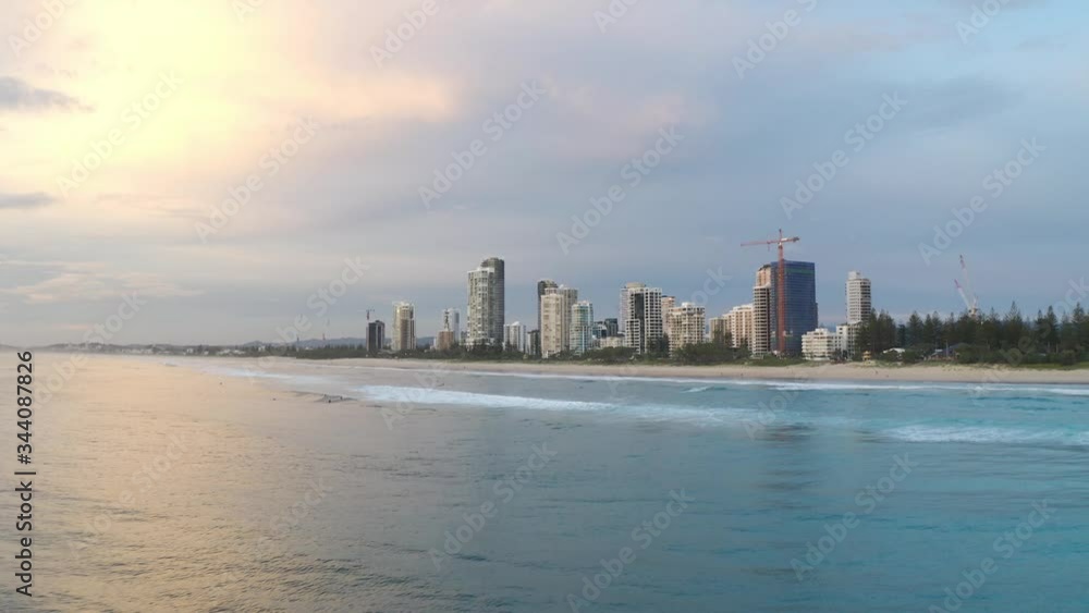 Sunrise golden hour aerial drone view from above the ocean looking at Broadbeach in Gold Coast, Queensland, Australia