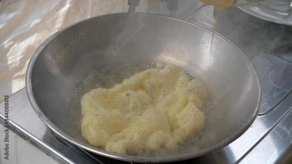chef cooking fluffy omelette in the kitchen. pouring mixed egg in to hot oil. 60FPS chef cooking fluffy omelette in the kitchen. pouring mixed egg in to hot oil. 60FPS