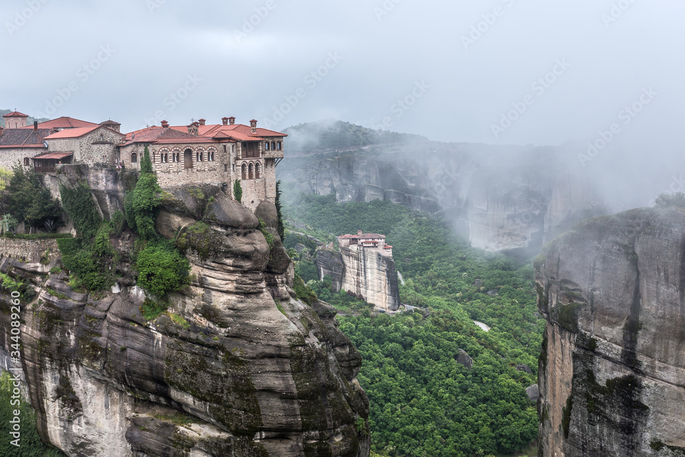Foggy landscape of Mysterious hanging over rocks monasteries of Meteora, Greece