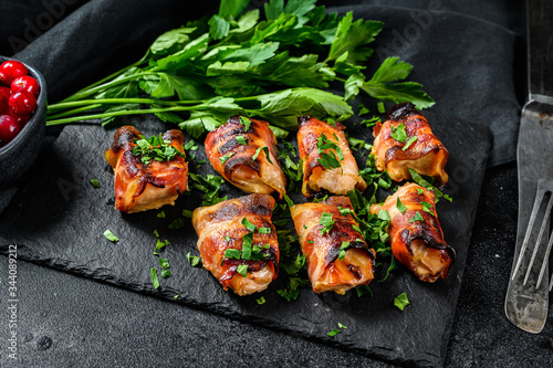 stuffed chicken breasts, fillets rolled in bacon. Black background. Top view