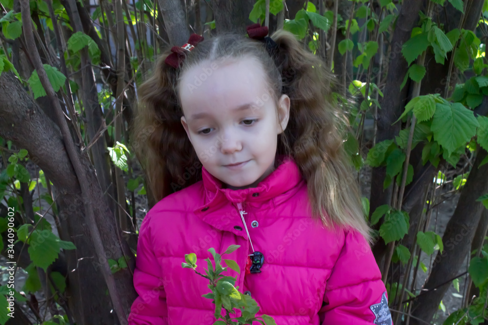 girl looks at a twig, spring in the garden. girl looks at a twig, spring in the garden.