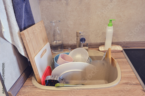 Kitchen sink filled to the top with dirty unwashed dishes before and after washing, concept