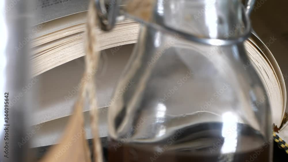 Close sliding shot of book and liquor bottle Close sliding shot of book and liquor bottle