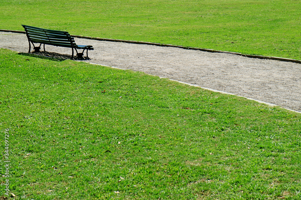 Empty bench on the green grass field in a park Empty bench on the green grass field in a park