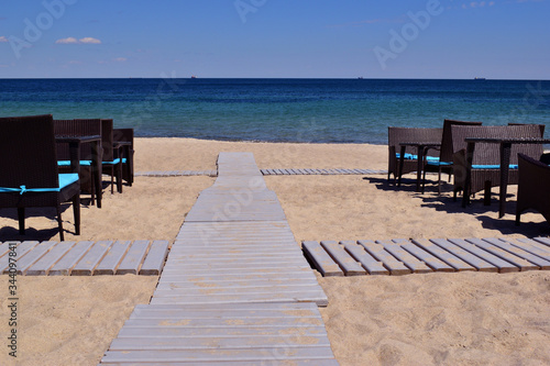   tables and wooden walkway along the food beach to the sea