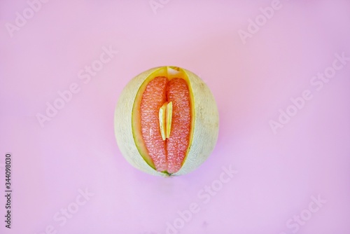 Sliced open melon with yonic fruit assortment over bright colorful background.