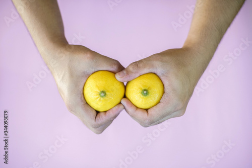 A pair of hands holding lemons with a firm grip.
