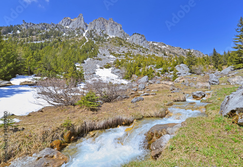 little fall flowing accross alpine mountain under blue sky