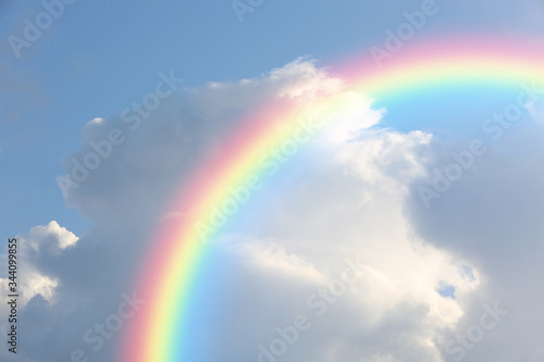 Picturesque view of beautiful rainbow and blue sky on sunny day