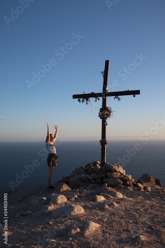 Woman with hands in air at cross