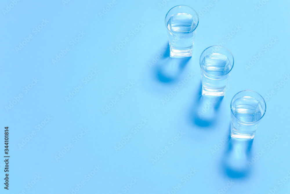 Glasses of water on a paper background. Drawing shadows. Classic Blue color. clean water concept Glasses of water on a paper background. Drawing shadows. Classic Blue color. clean water concept