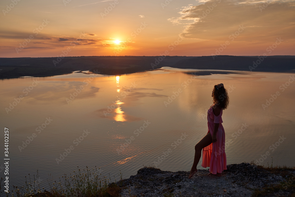 Girl in light dress on background of sunset near lake. Girl in light dress on background of sunset near lake.