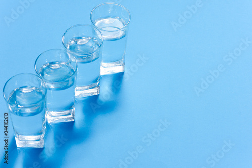Glasses of clean water on color background © Serhii
