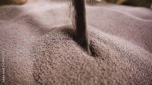 Close-up of loose material in factory. Stock footage. Processing of raw additives in bulk form on sifting conveyor of plant. Large amount of white bulk material at raw material processing plant photo