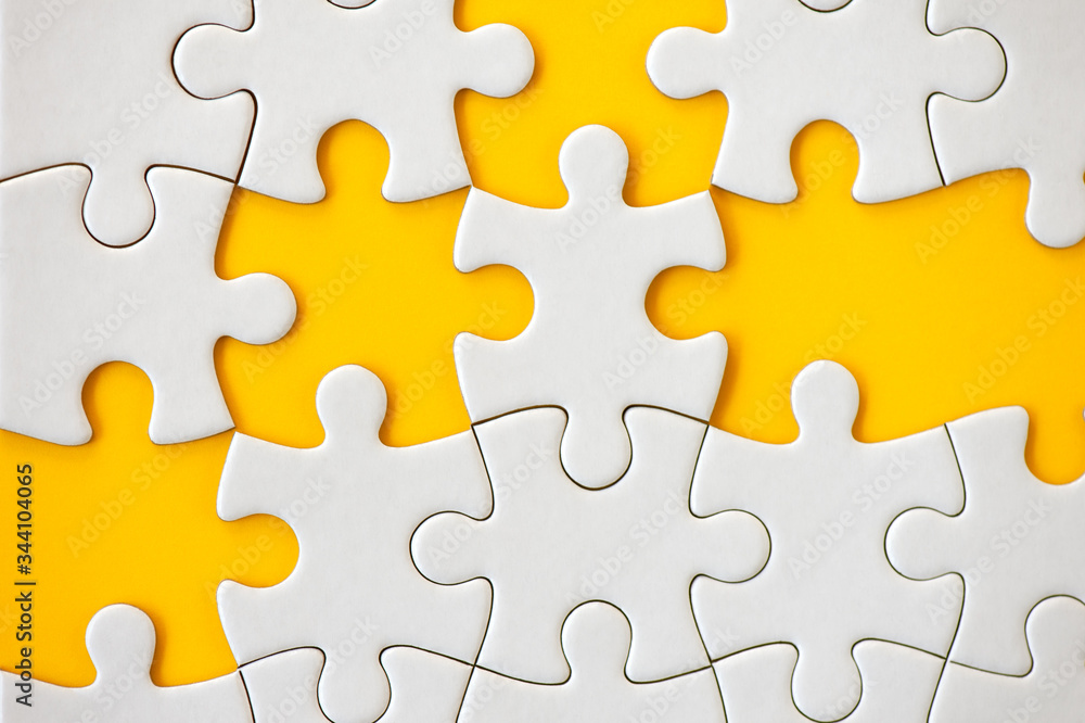 Obraz premium Puzzle pieces on orange background. White square puzzle pieces grid. Business background. Top view, close up.