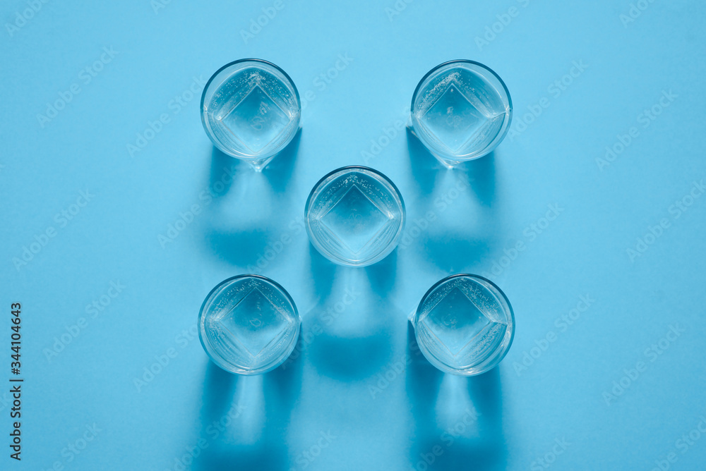 Glasses of clean water on color background