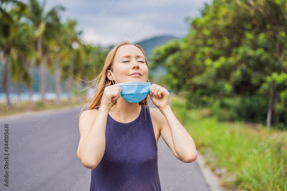 Quarantine is over concept. Woman taking off mask outdoor. We are safe. Coronavirus ended. We won. No more quarantine. Breathe deep. Take off the mask. Coronavirus is over Quarantine is over concept. Woman taking off mask outdoor. We are safe. Coronavirus ended. We won. No more quarantine. Breathe deep. Take off the mask. Coronavirus is over