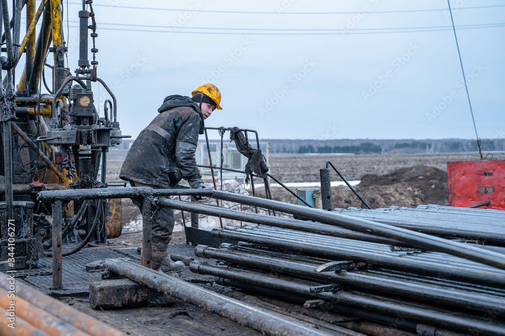 Workover rig working on a previously drilled well trying to restore production through repair. Offshore oil rig worker prepare tool and equipment for perforation oil and gas well at wellhead platform.
