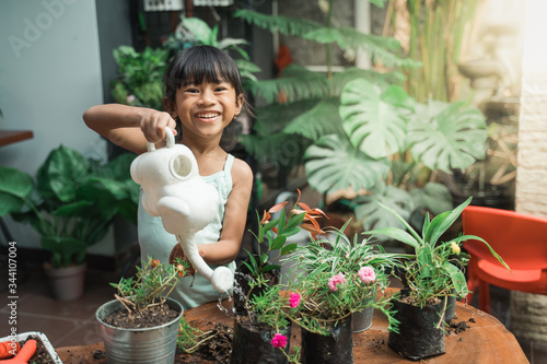 happy kid watering the plants at home