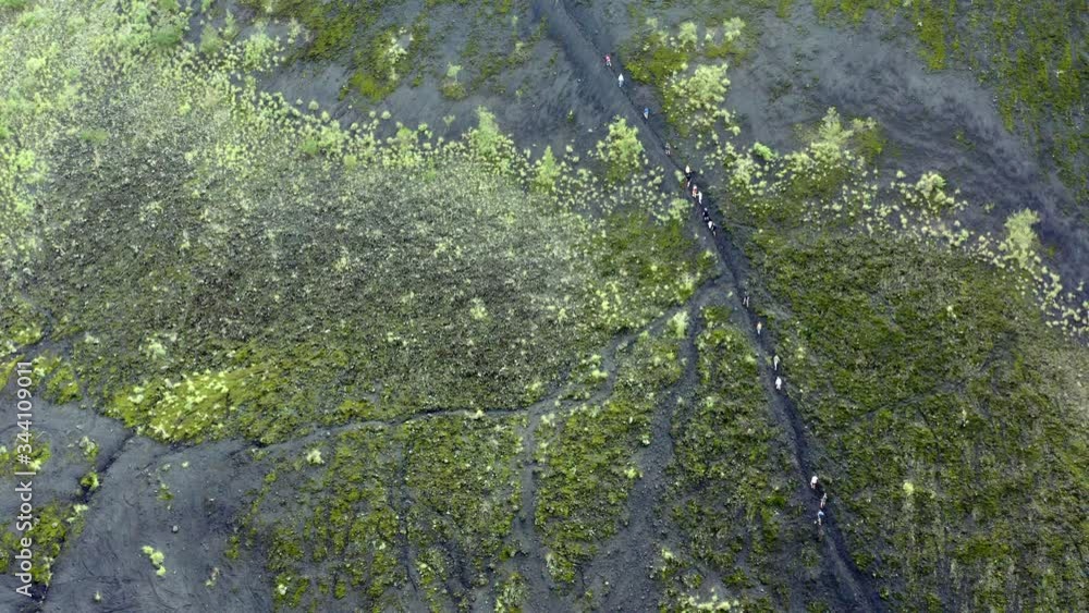 Mount Batur in Bali Indonesia with people hiking a foot trail to the caldera, Aerial hover shot Mount Batur in Bali Indonesia with people hiking a foot trail to the caldera, Aerial hover shot