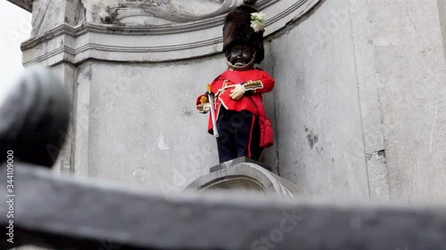 Manneken pis fountain statue in Brussels Belgium dressed up as a British soldier in bearskin hat, Pedestal up reveal shot photo