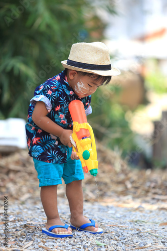 Lovely Thai boy aged 1 year 11 months playing water gun Songkran Festival in Thailand.