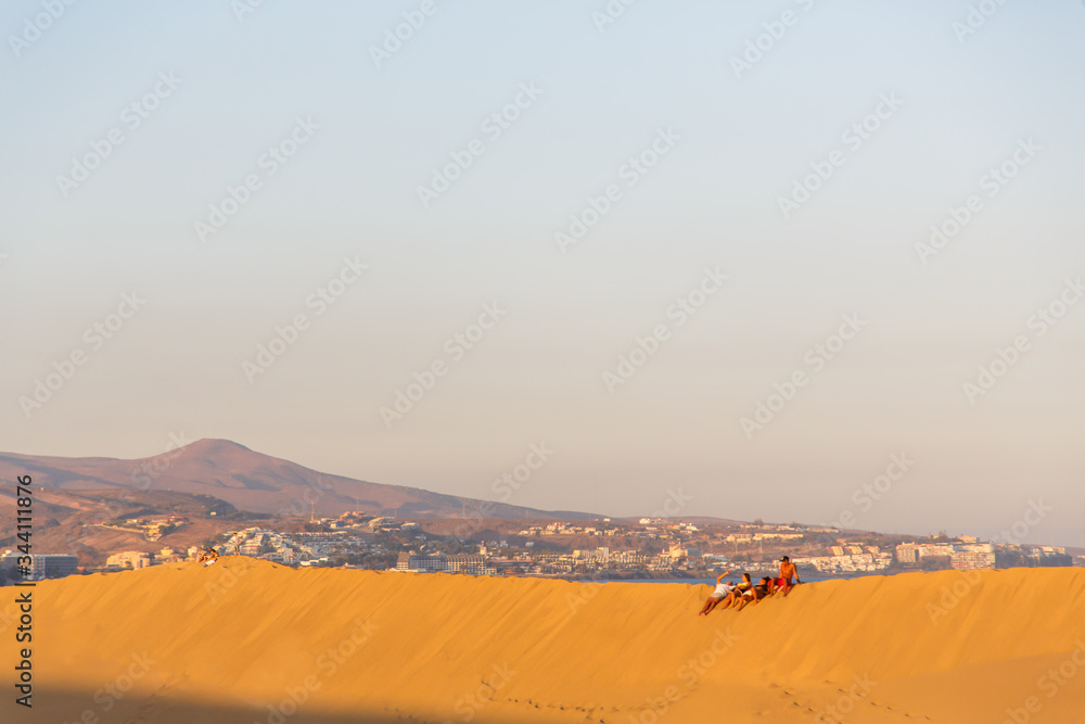 Maspalomas ,people sitting at the beach of Maspalomas Gran Canaria Spain, at the sand dunes desert of Maspalomas