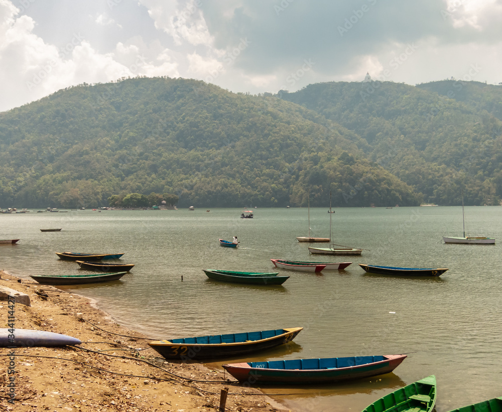 Wooden rowboats idling on the Phewa Lake in the Himalayan city of Pokhara.