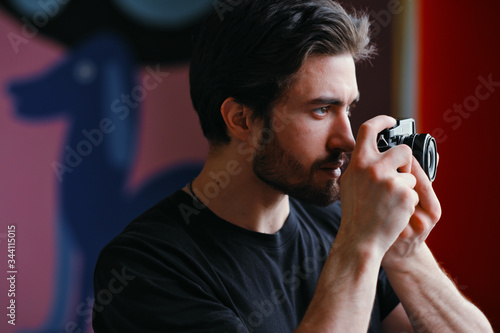 Male photographer uses a mirrorless camera to take a picture.