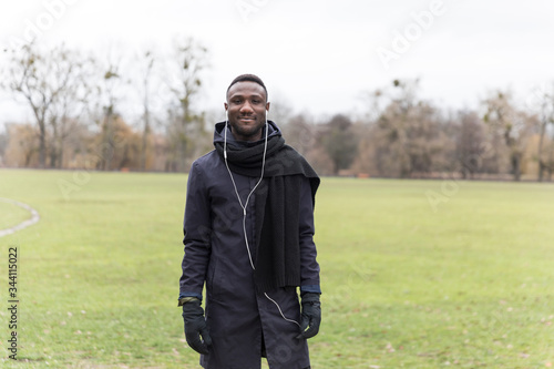 Young Black Man Posing on Park Grass in Autumn
