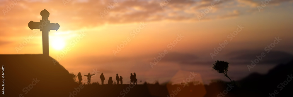 Fototapeta premium Silhouette of group people looking for the christian cross at sunset background. Idea for worship or praise god. panorama picture