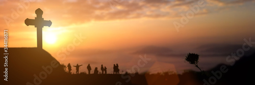 Silhouette of group people looking for the christian cross at sunset background. Idea for worship or praise god. panorama picture