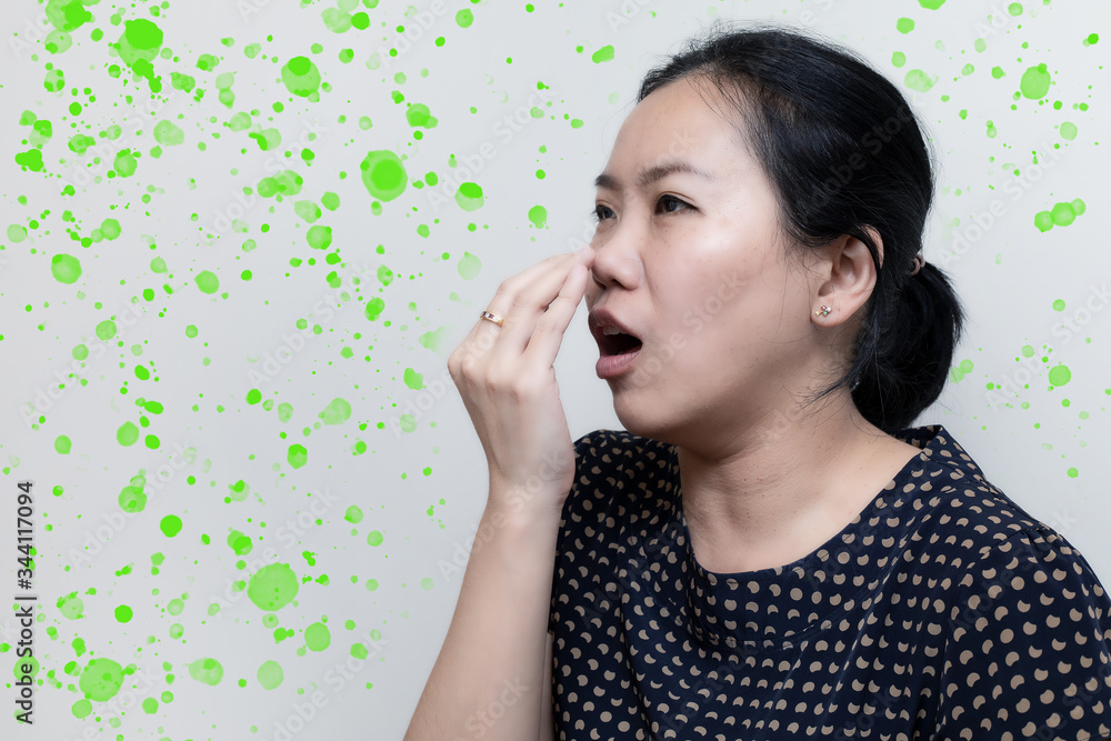 Portrait of Asian woman sneezing from VIRUS COVID-19 or epidemic disease. Health promotion concept. With spread of light green spots Portrait of Asian woman sneezing from VIRUS COVID-19 or epidemic disease. Health promotion concept. With spread of light green spots