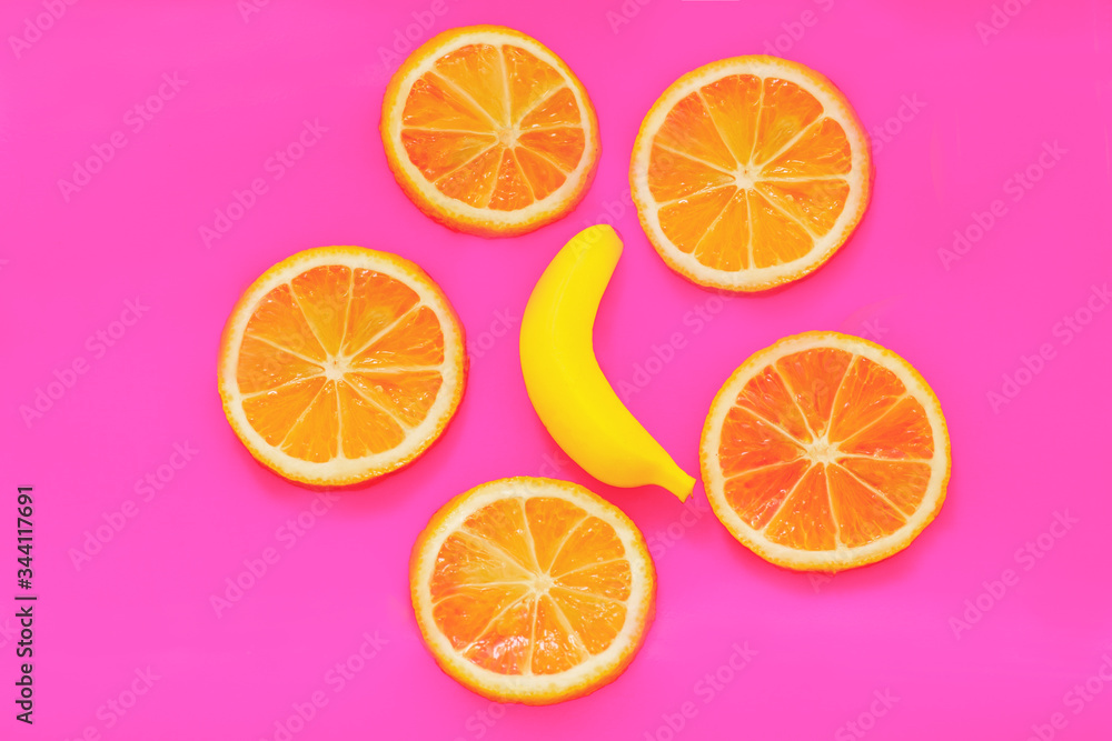 Yellow banana and oranges on pink paper. Fruits modern image. Flat lay. Top view. Pop art style. Creative minimalism. Yellow banana and oranges on pink paper. Fruits modern image. Flat lay. Top view. Pop art style. Creative minimalism.