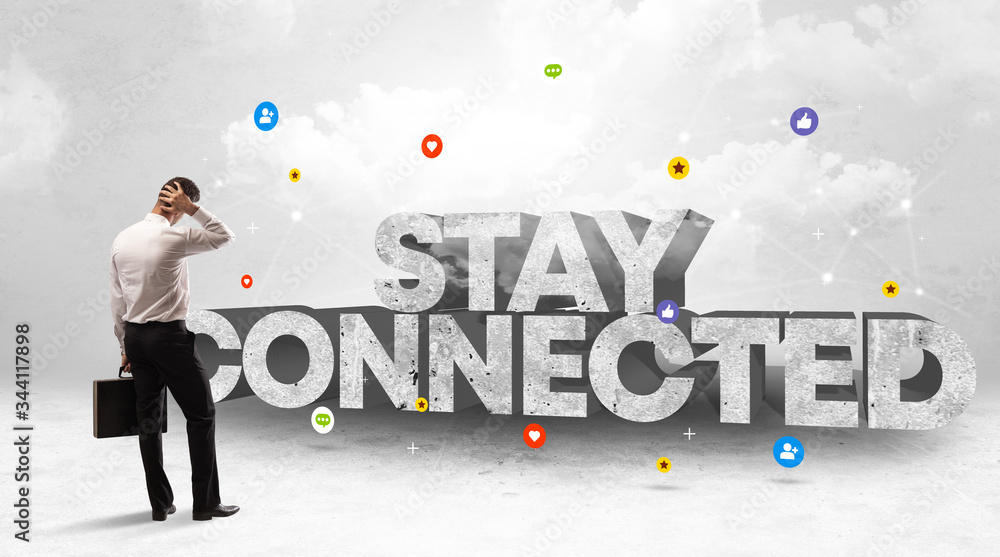 Young businessman standing in front of STAY CONNECTED inscription, social media concept Young businessman standing in front of STAY CONNECTED inscription, social media concept