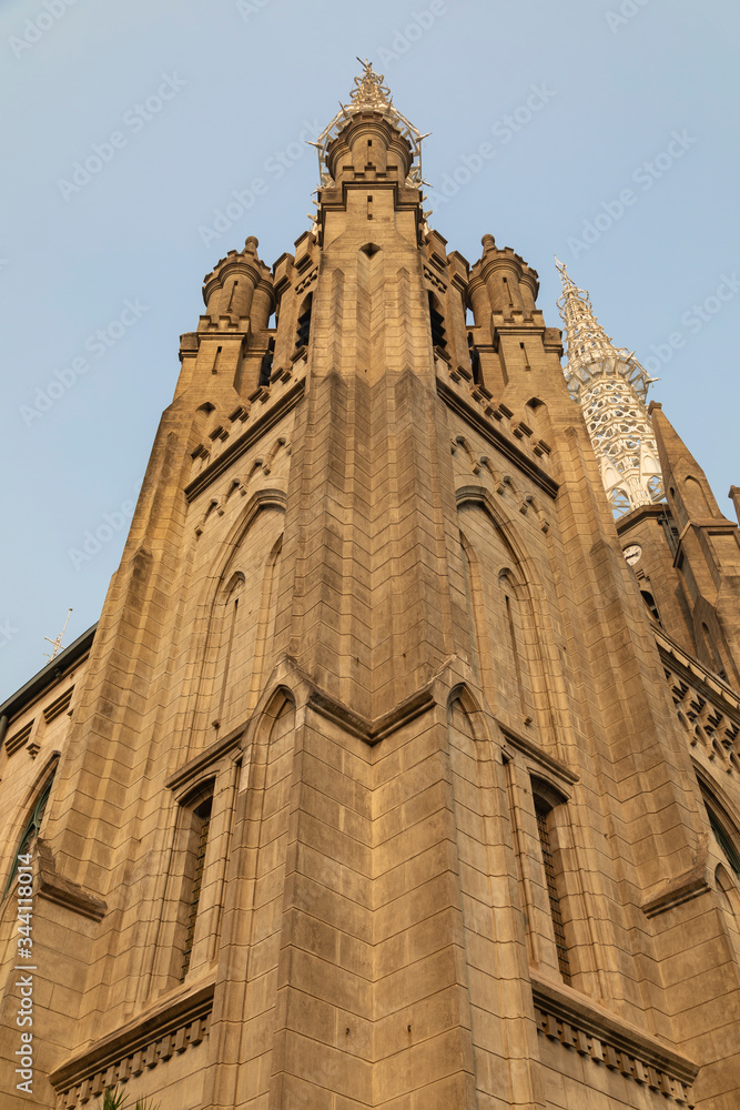 Low angle view of one of the towers guarding the portico of the main entrance to Jakarta Cathedral, Java Island, Indonesia, high above, the characteristic metal steeples of this temple.