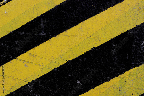 Warning painting of a post in a warehouse. Sign of attention for transport from yellow and black stripes. © MakZin