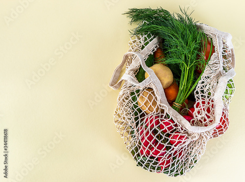 String bag of mixed fruit, vegetables and greens. Zero waste concept. Light background, copy space, top view, close up. photo