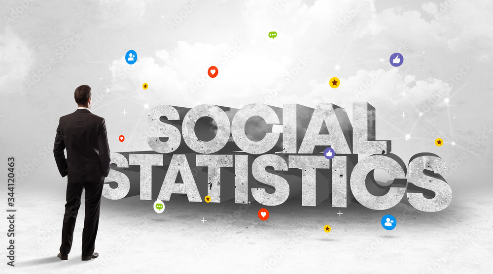 Young businessman standing in front of SOCIAL STATISTICS inscription, social media concept Young businessman standing in front of SOCIAL STATISTICS inscription, social media concept