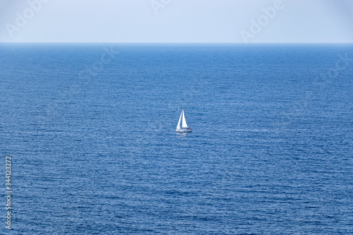 beautiful sailboat sailing in the distance in blue Mediterranean sea ocean, mallorca, spain © Martin