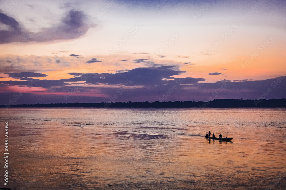 sunset on the amazon river with boat