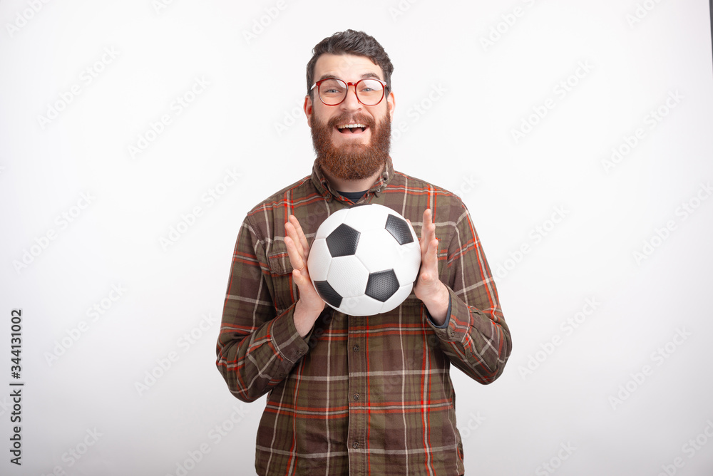 Smiling man is excited because he has caught the soccer or football ball on white background.