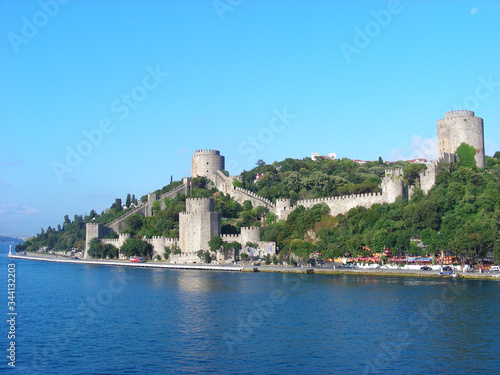 A fort with two towers and a defensive wall on an island in the sea. photo