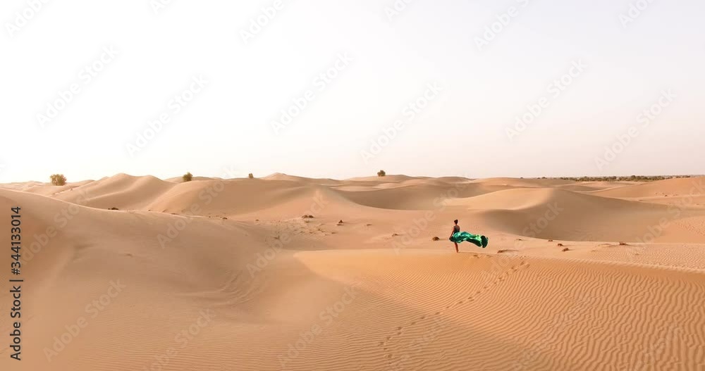 wide plan. view from the drone. desert and girl in a green dress areal shot wide plan. view from the drone. desert and girl in a green dress areal shot