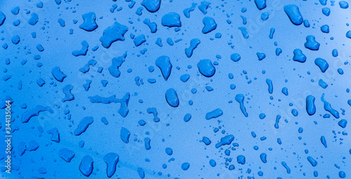 Rain drops on the blue car surface. Water srops on car hood. Water drops on blue metal surface.