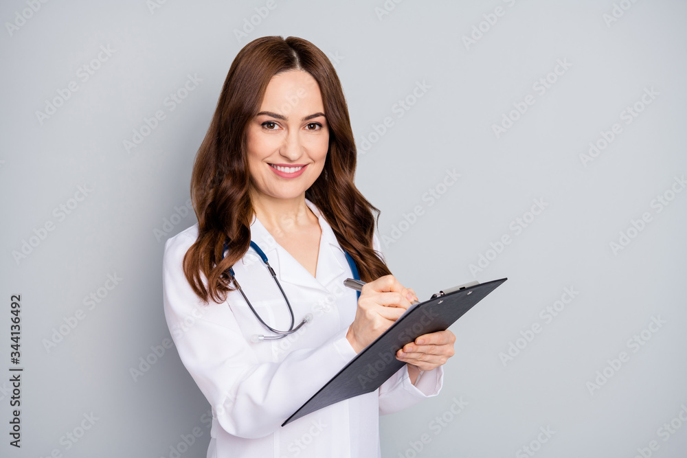 Close-up portrait of her she nice attractive cheerful wavy-haired doc phonendoscope stethoscope writing advice recommend meds isolated over grey pastel color background Close-up portrait of her she nice attractive cheerful wavy-haired doc phonendoscope stethoscope writing advice recommend meds isolated over grey pastel color background