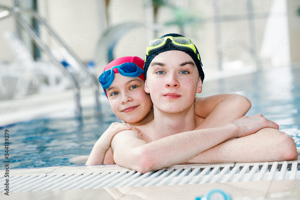 Siblings enjoying being in a swimming pool